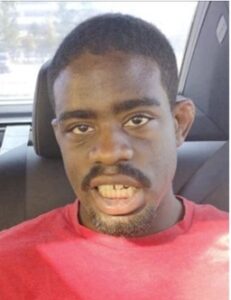 African American male wearing red t-shirt sitting in a car