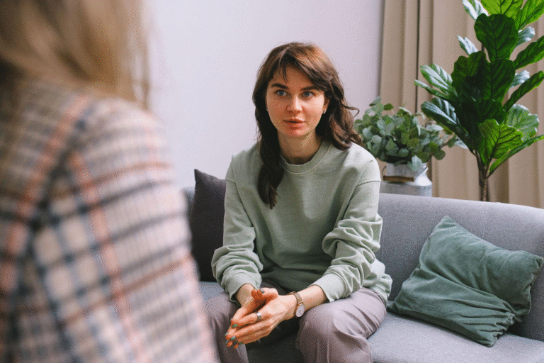 girl in green sweater sitting on a gray couch