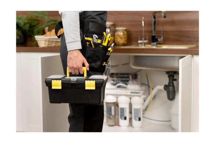 man holding a black and yellow toolbox and wearing a toolbelt with tools